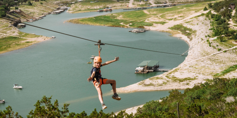 Kid Zipping down the longest and fastest zipline in Texas over Lake Travis.