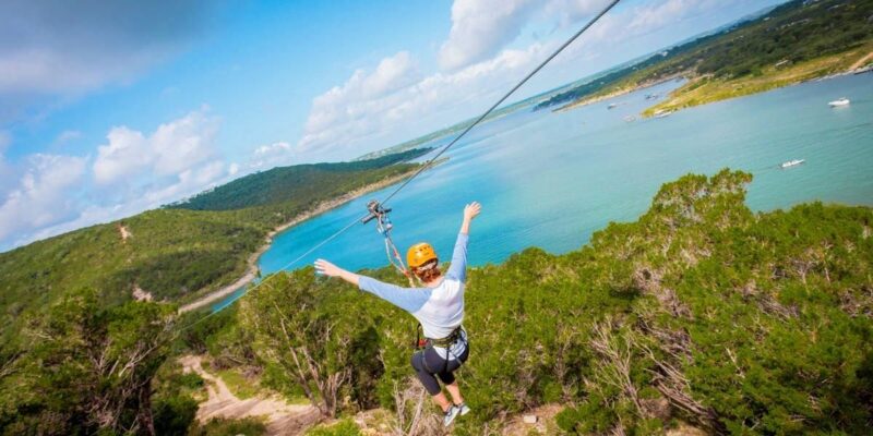 Person Soaring over Lake Travis mid flight with their arms out stretched