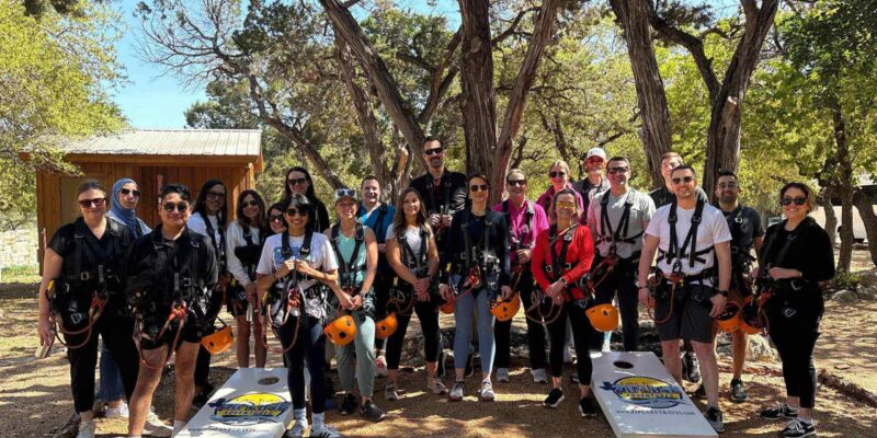 Corporate/ work event posing in front of corn hole game area