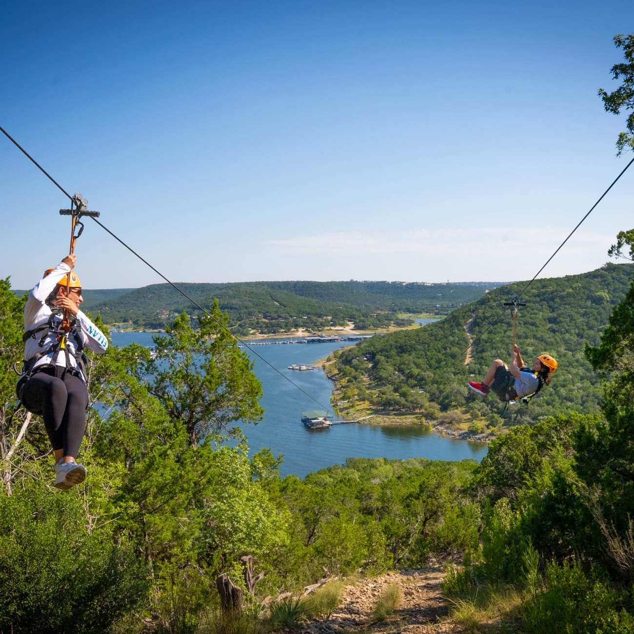 Two people going down 2,800 feet of zipline, the longest and fastest in Texas.